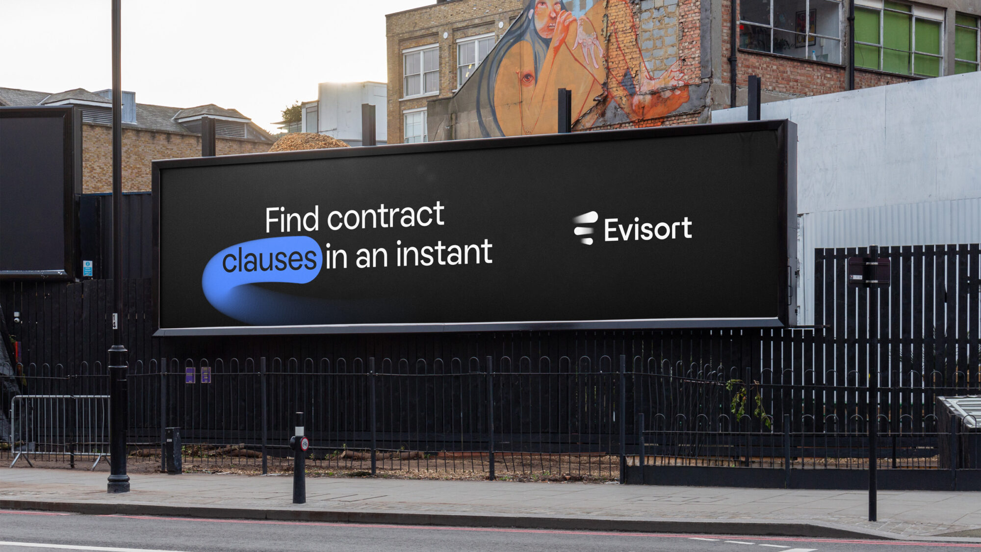 A street with a graphic Evisort poster pasted on a wall. It features a title “Find contract clauses in an instant”.