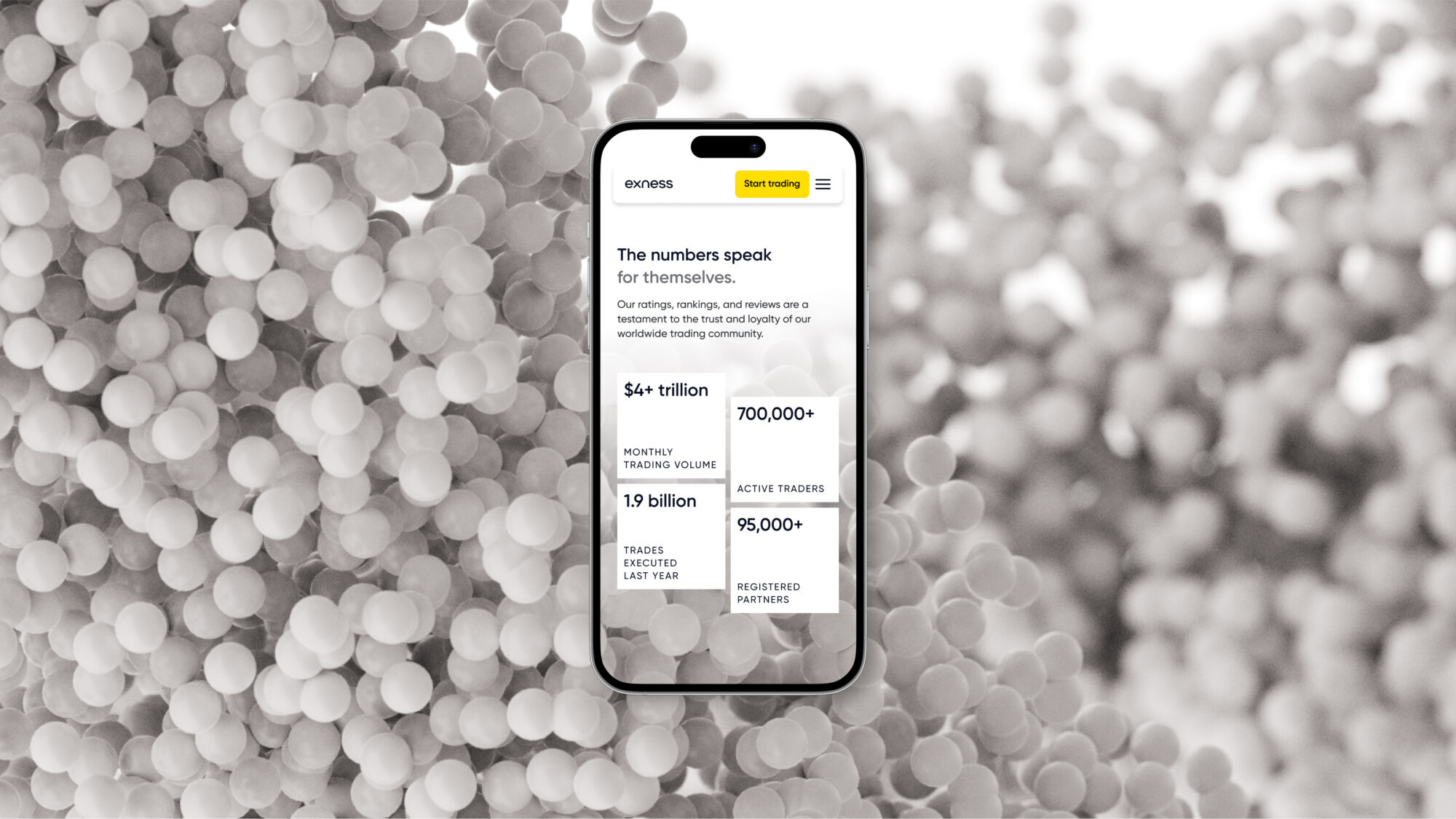 A phone on a brand texture background showing some key figures of Exness' performance on their website.